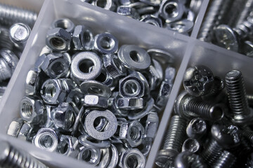 Close up of large assortment of metal and steel hardware. variety of nut, bolt, washer, and screw...