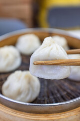 Pick up a xiaolongbao from the steamer with chopsticks