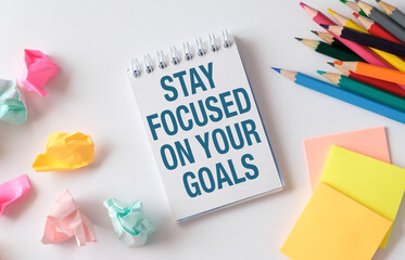 A notebook with the words Stay Focused on Your Goals written on it