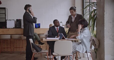 Diverse colleagues brainstorm and discuss analysis in a co working space coffee bar. A team works together, using a tablet and notes, in a casual yet professional setting. - Powered by Adobe