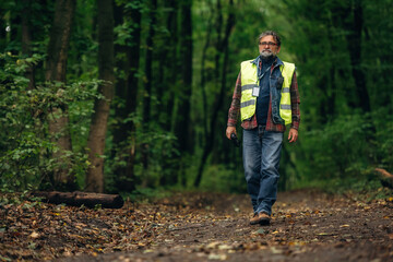 Senior forest ecologist is working in the woods. In the uniform
