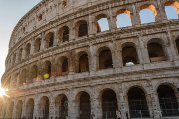 Fototapeta premium Colosseum in Rome, Italy – Ancient Amphitheater at Sunrise with Warm Light Through Arches