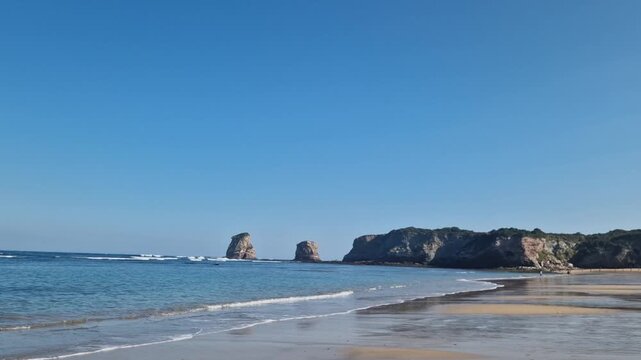 Video of Hendaye beach on a sunny autumn day, Basque coast, southwest France. Gentle waves, blue sky, and golden sand create a calm seaside atmosphere around noon. Ideal clip for travel, vacation, nat