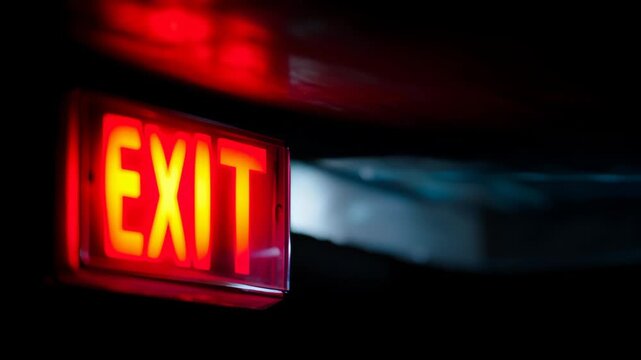 Bright red exit sign illuminated against a dark background for safety and guidance