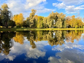 autumn trees reflection on the blue lake surface, autumn lake in the park