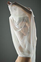 Fototapeta premium Elegant young dancer showcasing ballet grace with flowing fabric in a serene setting