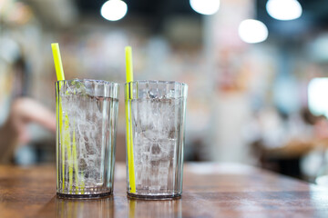 Two glasses of cool water with ice on wood table