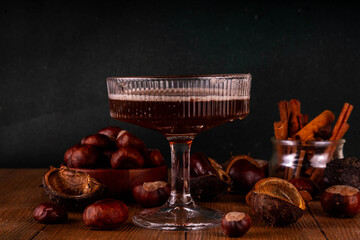 Strong alcohol chestnut martini cocktail, autumn dark and spicy alcoholic drink in martini glass with chestnut liquor and cinnamon