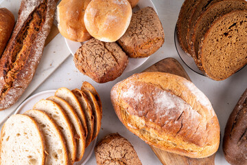 Set of various Prebiotic Bread with live bacteria, prebiotics, fiber for gut health. Healthy alternative to regular bread, different rye, white, grain bread and buns on white table background
