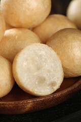 Hot fresh bread rolls with torn puffs in wooden bowl showing soft white interior texture