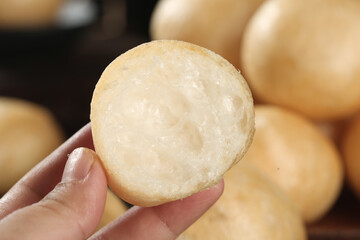 Fresh baked dinner roll with soft fluffy texture held in hand showing interior crumb