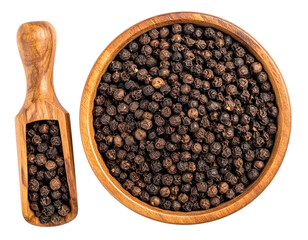 Wooden bowl and scoop filled with whole black peppercorns. Overhead view