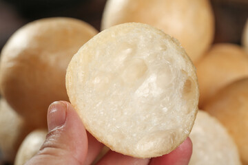 Fresh lotus root slice in hand showing natural texture and holes, healthy Asian cooking ingredient
