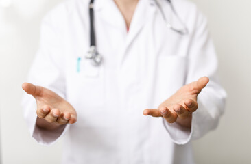 A doctor in a white coat extends his hands towards the viewer, offering help, care, and support....