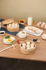 Traditional Chinese Breakfast with Xiao Long Bao Dumplings and Fresh Gourmet Food on Wooden Table