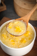 Sweet Millet Rice Porridge with Sweet Potato - Healthy Breakfast Bowl with Wooden Spoon