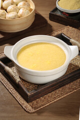 Healthy Yellow Porridge Rice Breakfast Bowl with Steamed Buns on Bamboo Serving Tray