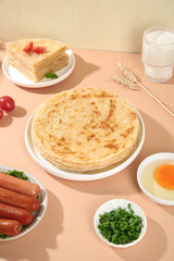 Handmade Golden Layered Pancakes and Pastries with Fresh Ingredients on Wooden Table