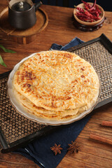 Crispy Pan Fried Homemade Flatbread Stack on Rustic Wooden Table with Star Anise Spices