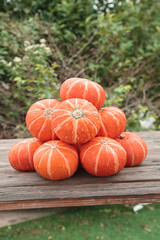 Fresh Orange Pumpkins Stacked on Rustic Wood Table - Autumn Harvest Garden Display