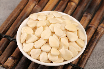 Fresh Peeled Sliced Almonds in White Bowl on Bamboo Mat - Healthy Nut Snack Ingredient