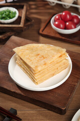 Handmade Buttered Crepes Stack with Fresh Vegetables on Rustic Wooden Board