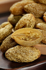 Dried Chaoshan Olive and Licorice Preserved Fruits Traditional Asian Snacks on Wooden Board