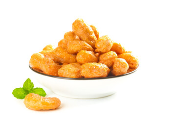 Fried Crispy Cashews Kernels in Bowl with Mint Garnish on White Background