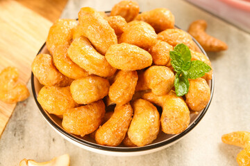Crispy Fried Cashew Nuts with Mint Garnish in Bowl on Wooden Background