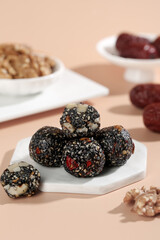 Handmade Black Sesame Energy Balls with Nuts and Dried Fruit on Marble Plate