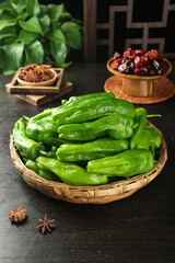 Fresh Green Peppers and Chinese Spices Cooking Ingredients in Traditional Wicker Basket on Dark Wood Surface