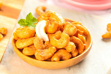 Deep Fried Crispy Cashew Nuts in Wooden Bowl with Mint Garnish - Healthy Crunchy Snack Food