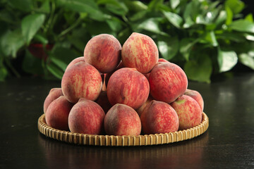 Fresh Ripe Peaches in Wicker Basket with Green Leaves Background - Organic Fruit Harvest Display