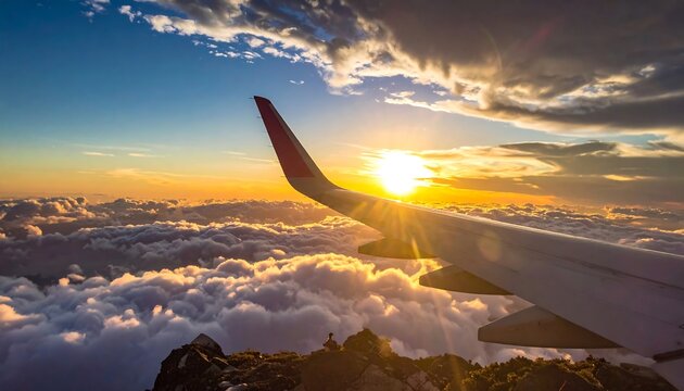 Aerial view of the plane wing at sunset, above the clouds - Powered by Adobe