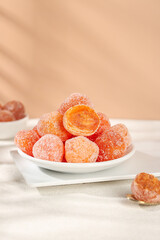 Sugar Coated Dried Kumquats and Oranges Traditional Tianshan Preserved Fruit Snacks on White Plate