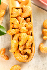 Roasted salted cashew nuts in wooden scoop - healthy snack food