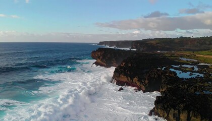 Obraz premium Aerial view of the rugged coastline with crashing waves