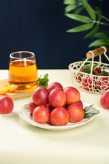 Fresh Red Plums on Plate with Tea Glass - Healthy Organic Fruit Snack Food Photography