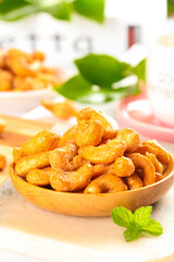 Roasted Golden Cashew Nuts in Wooden Bowl with Fresh Mint Healthy Snack Food