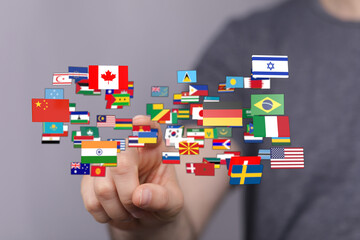 A hand pointing at various country flags symbolizing global unity, diversity, and international relations. Ideal for concepts like globalization