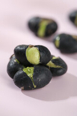Fresh Black Beans Split Open Showing Green Interior Seeds on White Background