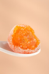 Sweet Orange Kumquat Candy Covered in Crystal Sugar on Beige Background