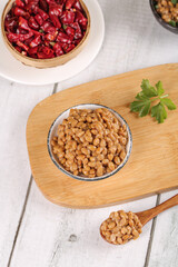 Japanese Natto Fermented Soybeans in Bowl with Red Chilies on Wooden Board - Traditional Asian Food