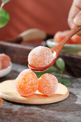 Traditional Sugar Coated Dried Kumquat Fruit Preserves on Wooden Spoon Asian Confectionery Sweets