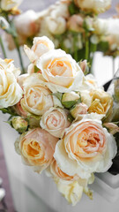 colorful flowers in a wedding arrangement close-up. peach roses in a plastic container