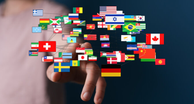 A person's hand reaching towards a collection of international flags, symbolizing global connectivity, communication, and the digital world.
