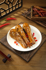Asian Braised Duck Head Delicacy with Spices and Chili Peppers on Wooden Table