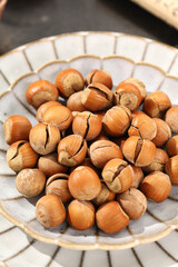 Fresh hazelnuts in ceramic bowl - shelled and unshelled nuts for healthy snacking and cooking ingredients