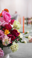 colorful wedding ekibana in vase on wedding tables in hall . Wedding flower arrangement. Ranunculus, gerbera, rose, carnation
