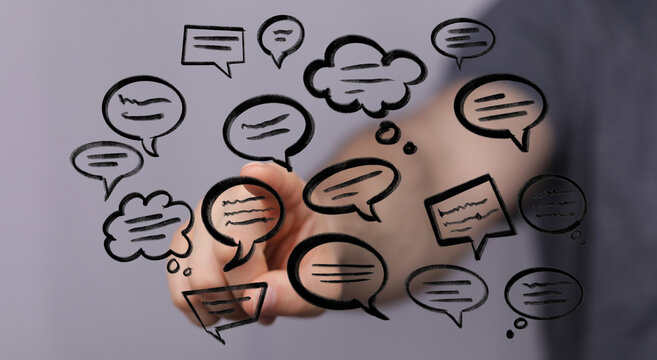 Hand pointing at digital speech bubbles. Illustrates communication, technology, and the importance of online conversation.